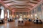 Salón del mansion decorado para boda con mesas, sillas y centro floral
