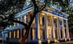 Fachada iluminada del museo por la noche, destacando su arquitectura neoclásica