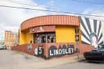 Vista exterior del local con fachada amarilla y mural