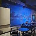 Interior del club con iluminación azul y decoración de ciudad nocturna en la pared