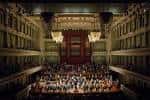 Interior del auditorio con orquesta en escena y arquitectura clásica