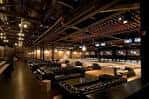 Sala de eventos con mesas dispuestas para cena y pista de bolos al fondo
