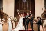 Pareja celebrando su matrimonio al pie del altar con acompañantes