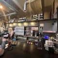 Interior del bar de Black Sky Brewery con ambiente industrial y clientes