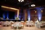 Salón interior del museo decorado para una boda o evento formal con mesas redondas y iluminación ambiental