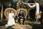 Ceremonia de boda con pareja sentada frente a un arco decorado