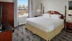 Habitación estándar con cama king size y vista a la ciudad desde el balcón