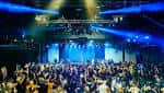 Interior del club ReelWorks Denver con iluminación azul y público en la pista de baile