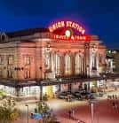 Fachada iluminada de Denver Union Station al atardecer