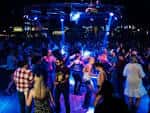 Interior del venue con público bailando bajo luces de concierto