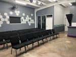 Sala de eventos interior con sillas negras y decoración moderna