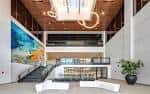 Interior moderno del lobby con escalera, arte mural y mobiliario contemporáneo