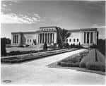 Fachada clásica del museo en blanco y negro con jardines frontales