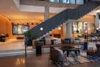 Lobby principal con escalera de diseño y zona de estar acogedora