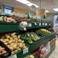 Interior del mercado mostrando estantes llenos de frutas y verduras frescas