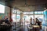 Interior del bar con mesas y clientes en ambiente relajado