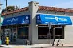 Fachada exterior de Mike Hess Brewing Ocean Beach con toldos azules