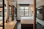 Habitación moderna con cama doble y baño de vidrio