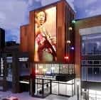 Fachada del museo al atardecer con gran mural de artista musical en la pared lateral