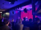 Concierto en vivo en el Black Lodge con público y escenario iluminado