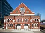 Vista exterior del Ryman Auditorium con su icónica fachada de ladrillo rojo y arquitectura neoclásica