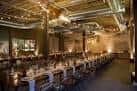 Sala de eventos decorada con mesas largas y luces cálidas