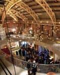 Vista interior del auditorio con estructura de madera y público en evento