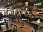 Interior del bar con mesas y clientes sentados