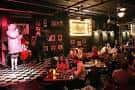 Interior del Rainbow Room con escenario y público disfrutando de la música en vivo