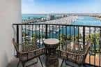 Balcón privado con vistas al mar y al puerto desde una habitación del hotel