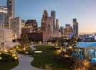 Vista panorámica del rooftop Skylawn en Houston con césped, senderos y skyline urbano al atardecer