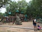 Zona recreativa del parque con niños jugando y equipamiento al aire libre