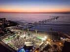 Vista aérea nocturna del evento OB Oktoberfest en la playa con el muelle iluminado al fondo