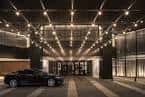 Entrada principal del Four Seasons Hotel Houston con coche de lujo bajo marquesina iluminada