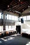 Interior del espacio de eventos con techos altos y grandes ventanales