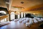 Interior del Crystal Ballroom configurado para evento con mesas redondas cubiertas y arcos decorativos