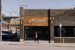 Fachada exterior de Mildred's con letrero de madera y arquitectura moderna