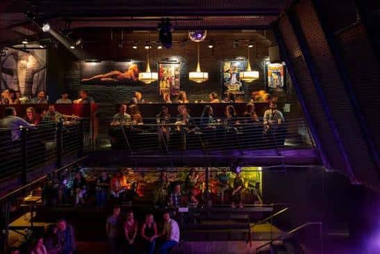 Vista panorámica del interior del venue mostrando el escenario y las mesas en diferentes niveles