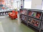 Área de lectura con estanterías de revistas y asientos cómodos