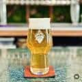Vaso de cerveza artesanal sobre mesa en el área de consumo