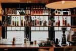 Interior del bar con estanterías de botellas y ambiente acogedor
