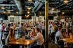 Interior del Taproom de Jackalope Brewing Company con clientes disfrutando en mesas y ambiente festivo