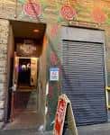 Entrada exterior de Alley Taps con murales coloridos y puerta abierta