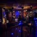 Interior del bar con iluminación azul y ambiente festivo nocturno
