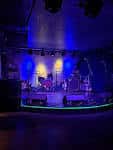 Plano cenital del escenario con equipo musical bajo iluminación azul