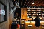 Interior del bar Barrel Proof con estanterías de botellas y ambiente acogedor