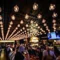 Interior del salón con iluminación cálida y ambiente festivo lleno de gente