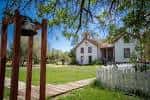 Casa histórica blanca con valla y campana en primer plano