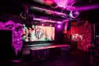 Escenario principal del club con iluminación en tonos rosados y morados