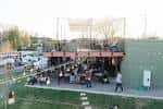 Plaza al aire libre durante el día con mesas, sombrillas y personas disfrutando del ambiente